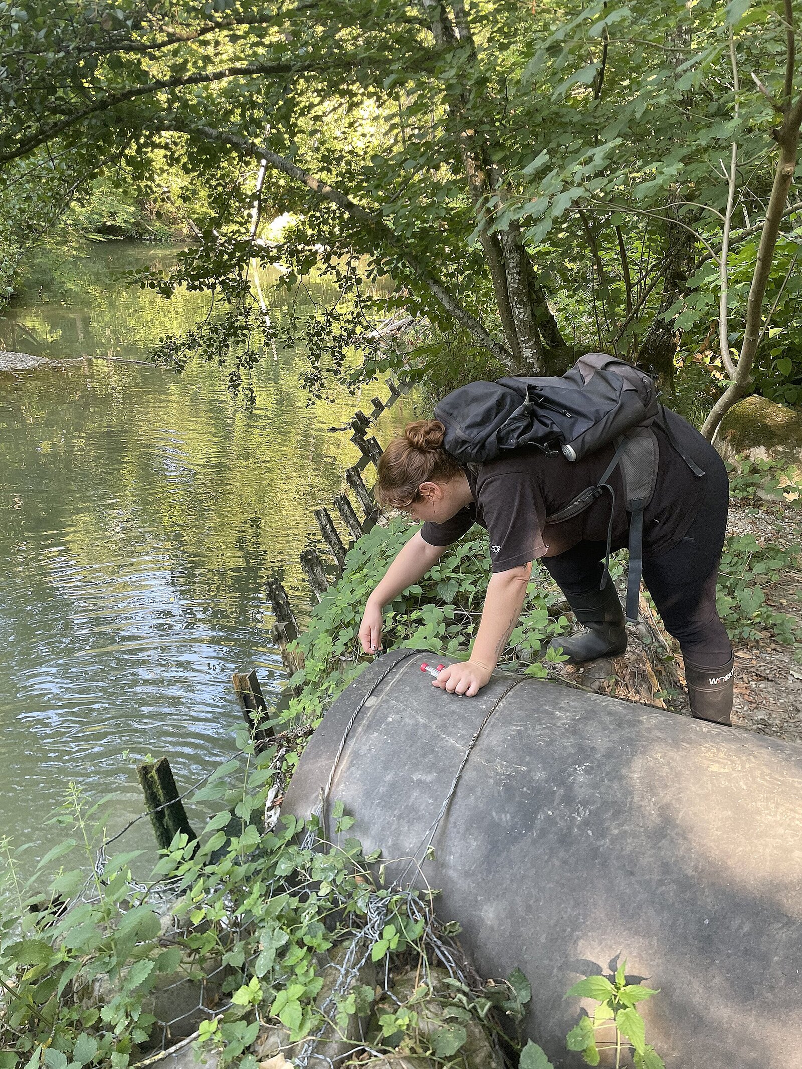 Léane balance son éprouvette pour récupérer un peu d’eau qui s’écoule d’un tuyau. © Réseau Romand Science et Cité